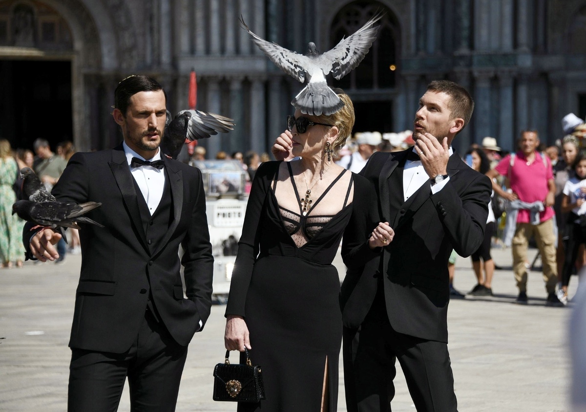 Sharon Stone con una paloma posándose en su cabeza y dos modelos