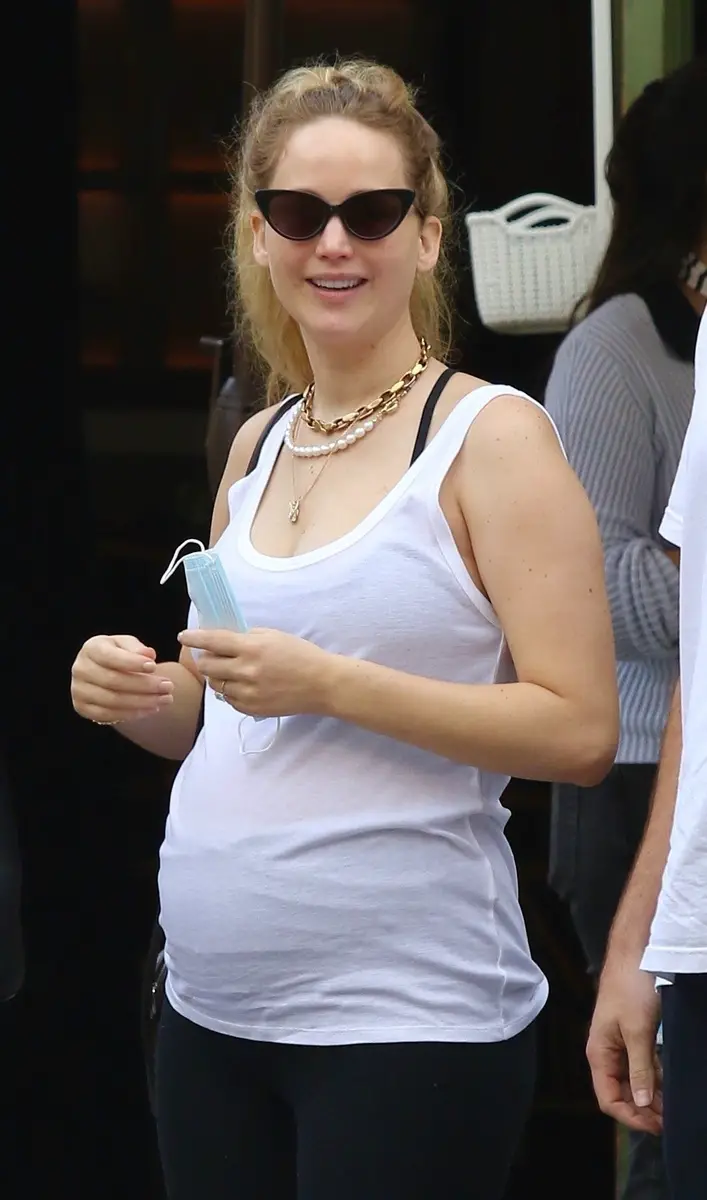 Jennifer Lawrence, una de las últimas novias de Chris Martin, sonriente en la calle, con camiseta de tirantes y gafas de sol