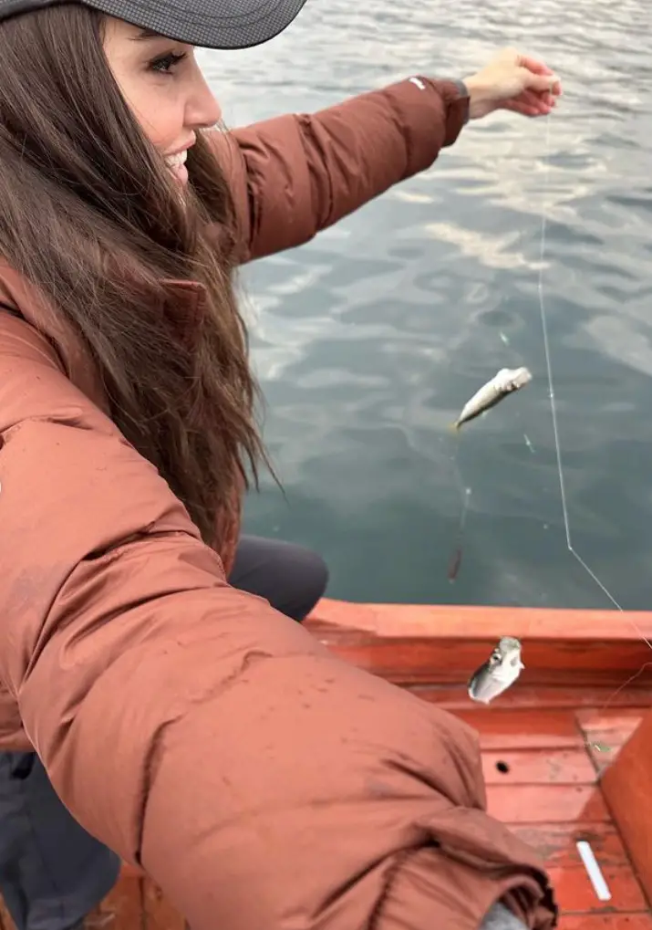 Hande Erçel muestra un par de ejemplares de pececitos que ha pescado.