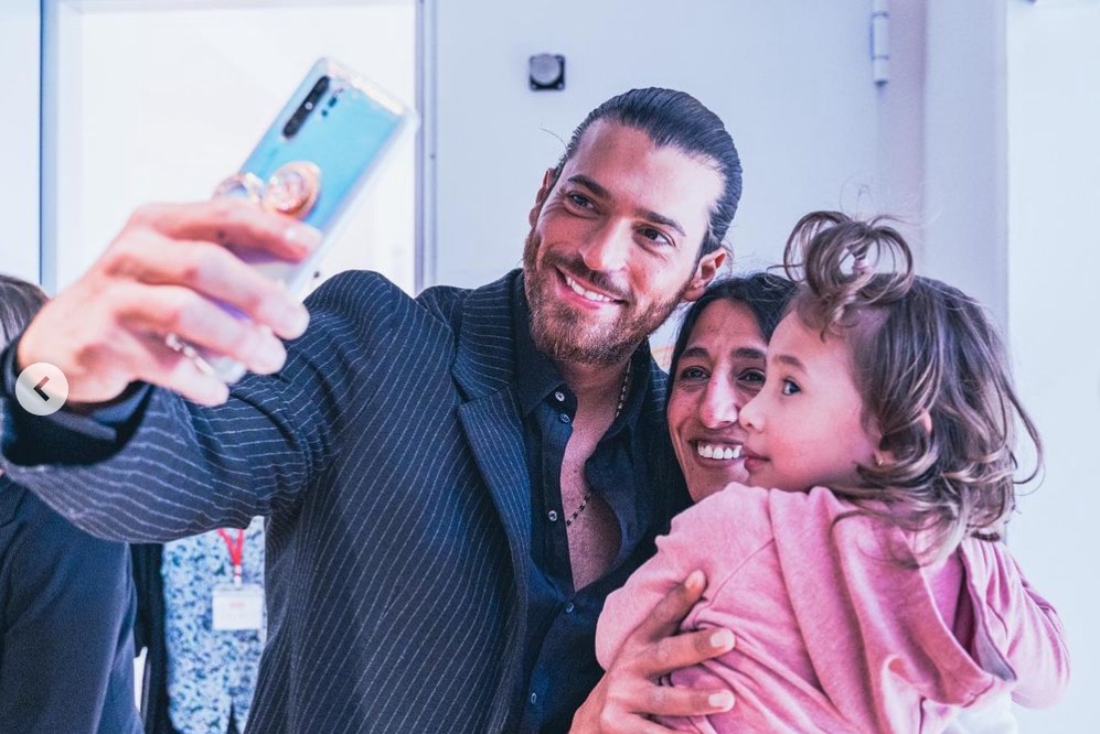 Can Yaman haciéndose un selfi con una mujer y su hija