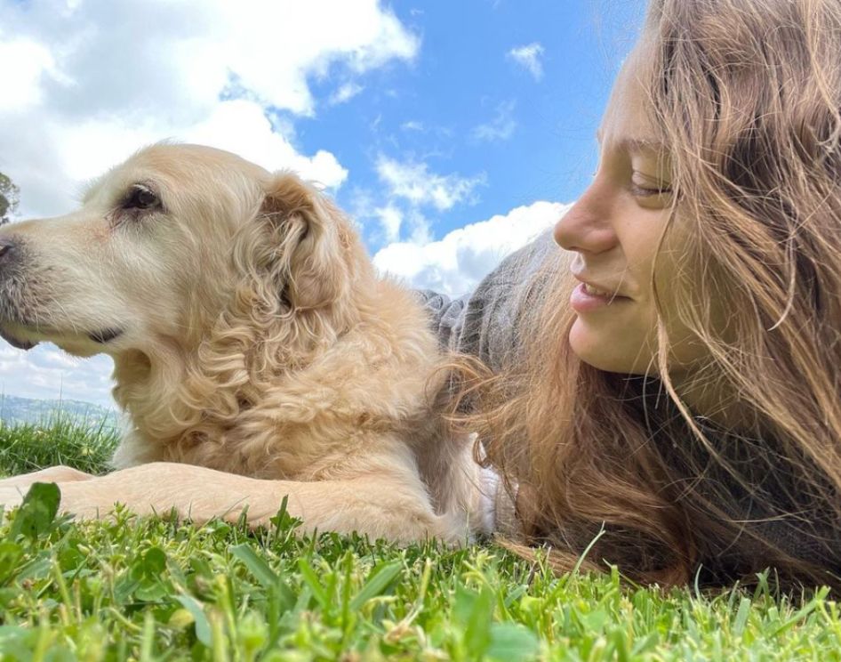 Serenay Sarikaya con su perro Orpheus, tumbados ambos en la hierba