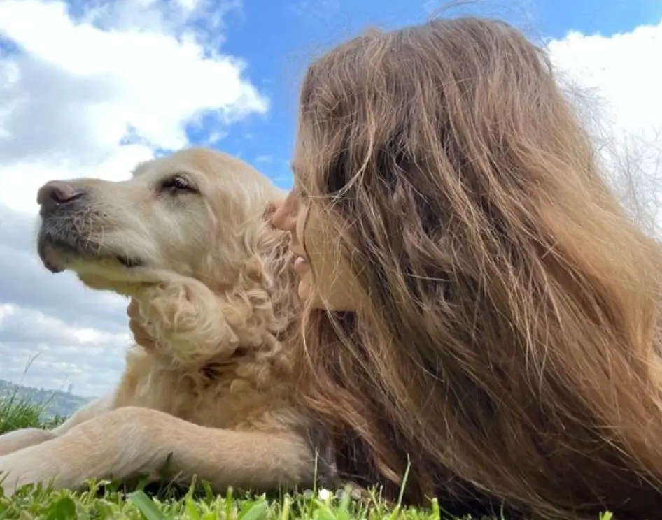 Serenay Sarikaya con su perro Orpheus, tumbados ambos en la hierba