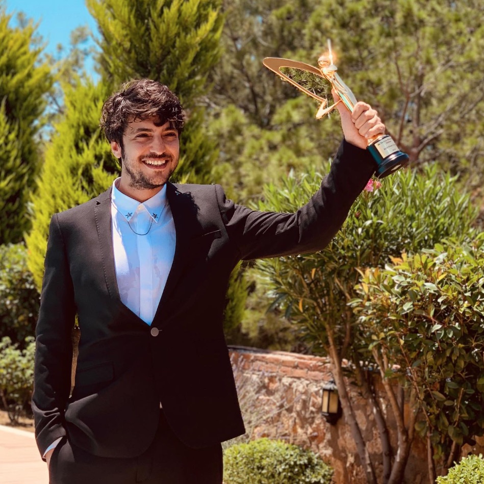 Taner Ölmez sosteniendo un premio, el Ayakli Gazete TV Stars
